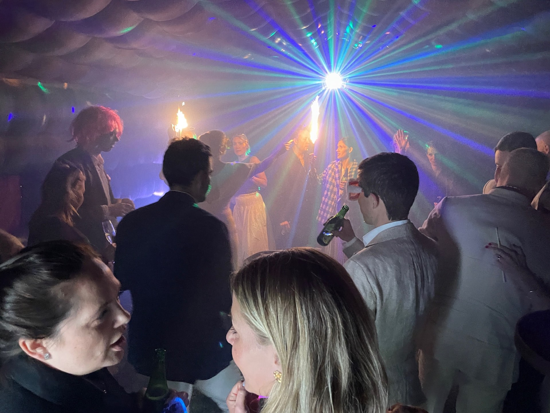 Gäster festar inne i det svarta uppblåsbara tältet under discobelysning