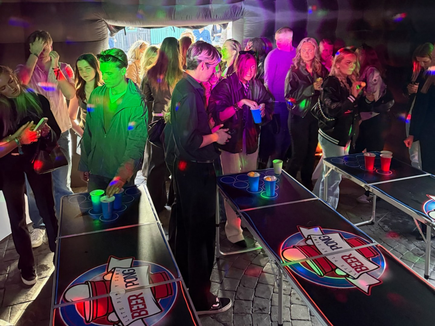Beer pong-bord inne i det svarta uppblåsbara tältet