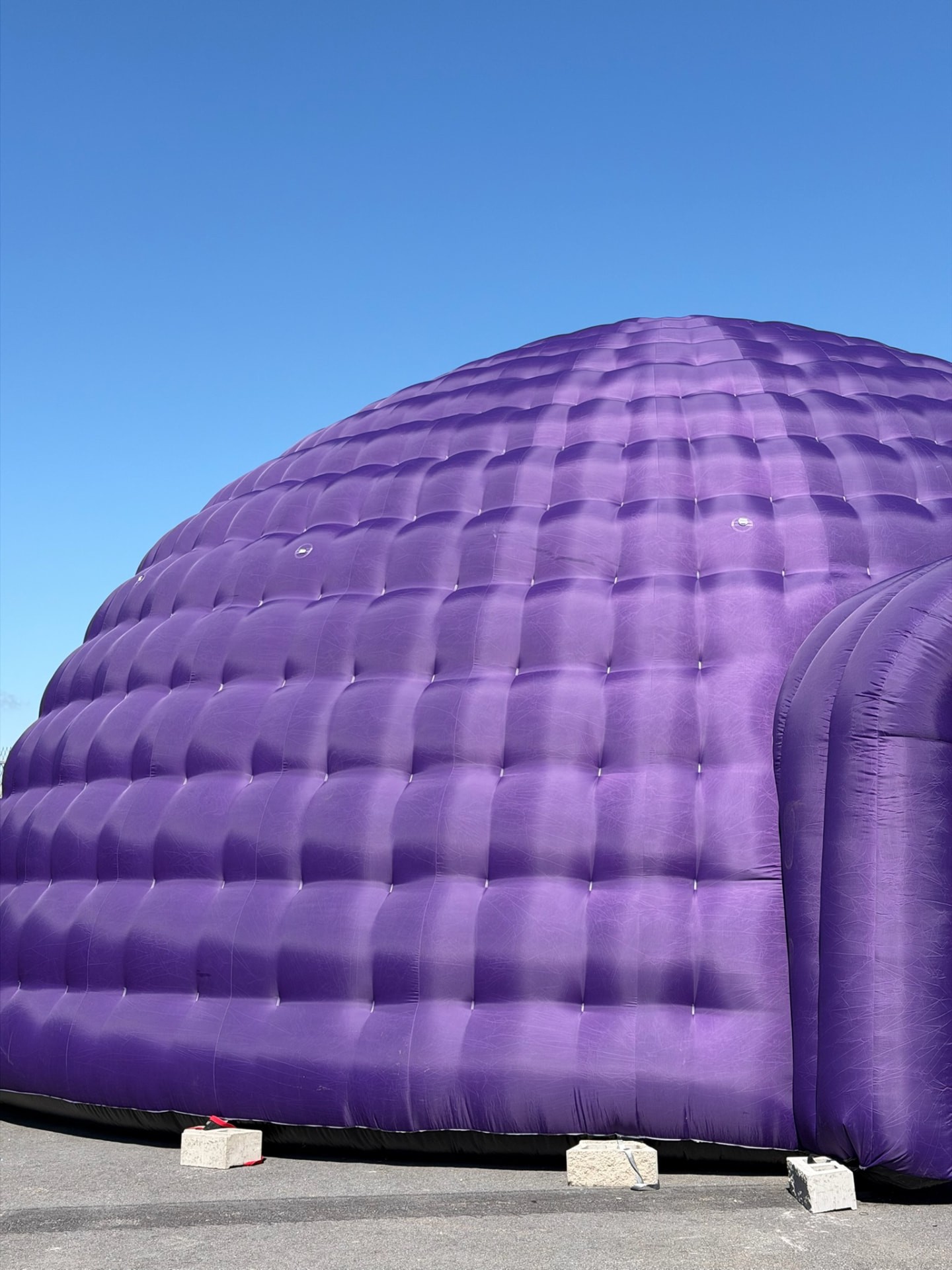 Den lila Igloon uppblåst mot en klarblå himmel
