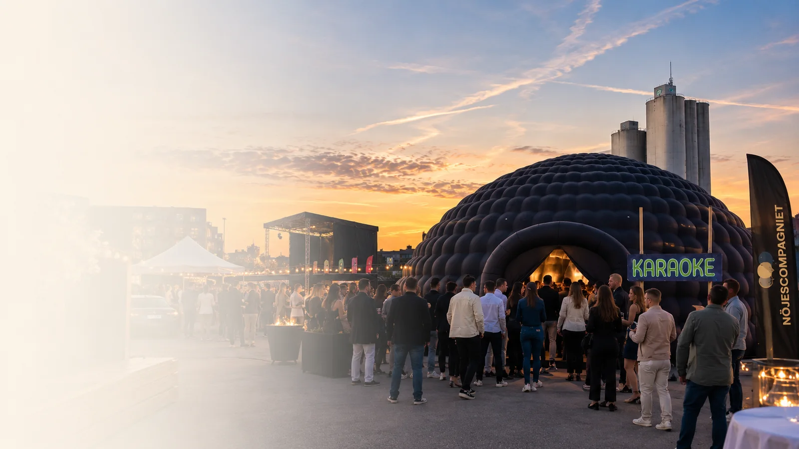 Nöjescompagniets stora svarta uppblåsbara Igloo med entré och gäster vid ett kvällsevent